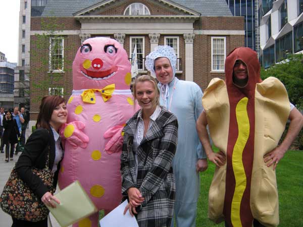 Two participants posing with a man in a Mr. Blobby suit as part of a City challenge.